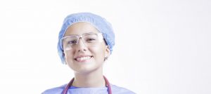 nurse smiling with hairnet and protective glasses