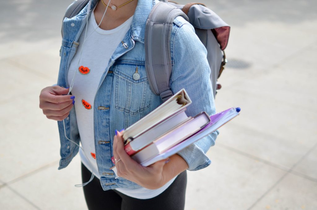 College student walking around campus with books