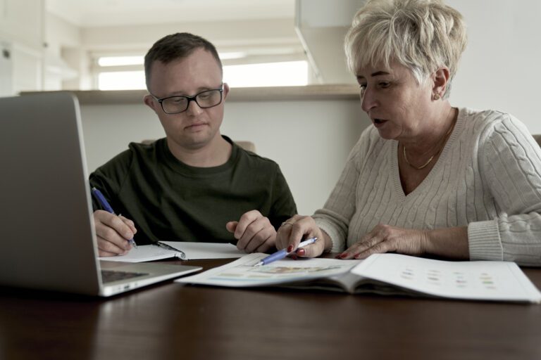 man with down syndrome studying with lady