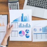 Female accountant calculations, audit and analyzing financial graph data with calculator and laptop Business, Financing, Accounting, Doing finance, Economy, Savings Banking Concept.